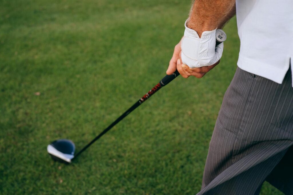 A golfer's hand grips the club firmly, poised for the next swing on the lush green course.